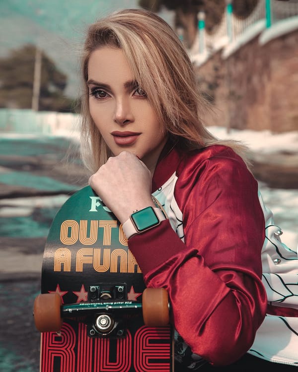 beautiful woman in red and white long sleeve shirt holding skateboard
